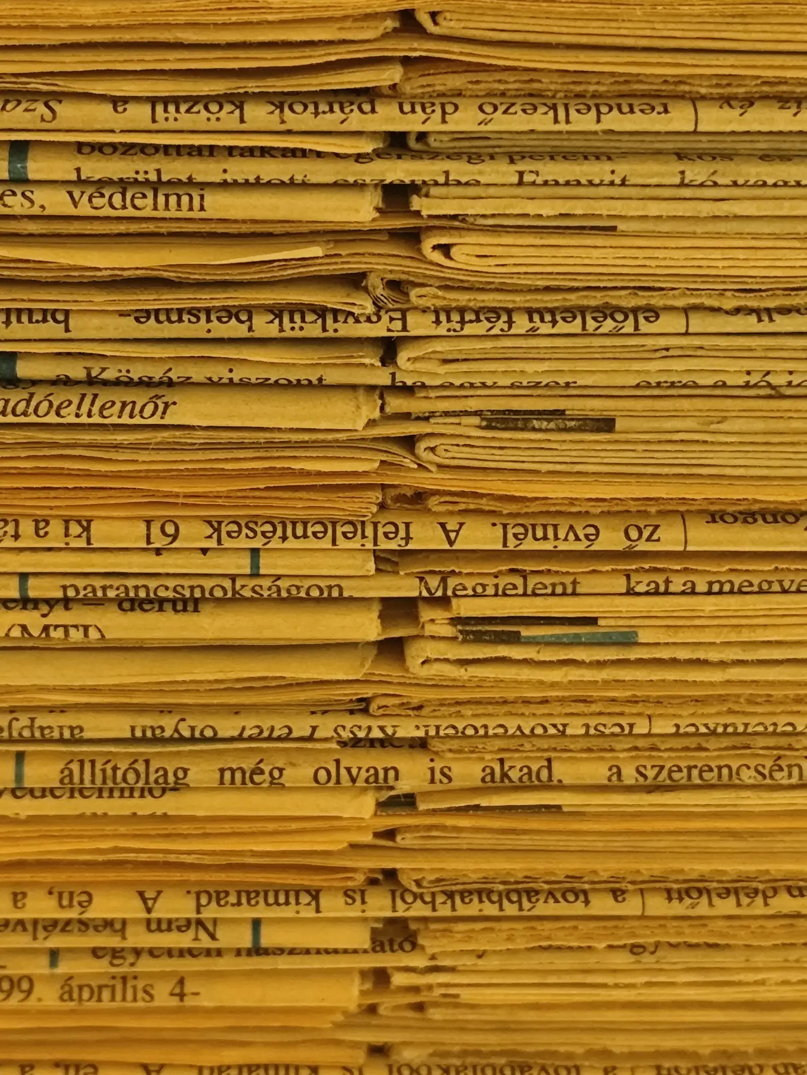 Close-up of stacked newspapers seen from the side.